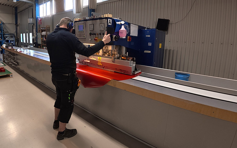 Operatør, der står og udfører HF-svejsning på et rødt tæppe