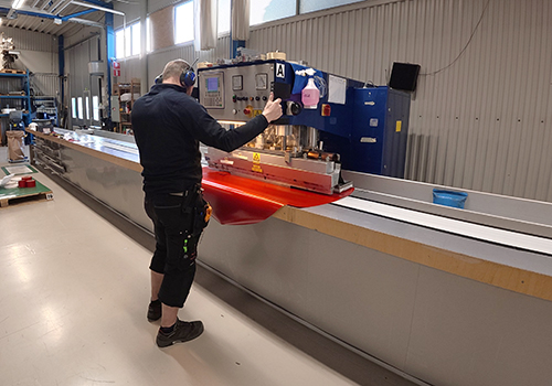 Operatör som står och utför HF svetsning på en röd duk